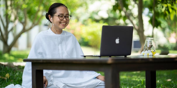 a woman sitting on a bench in a park giving online yoga sessions