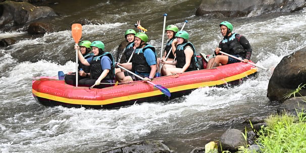 Tourists enjoying thrilling white water rafting adventure in Ubud Bali jungle river