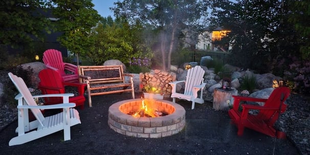 Cozy backyard fire pit with Adirondack chairs and ambient lighting in London, Ontario.