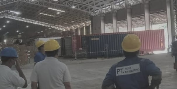 a group of people standing in a warehouse