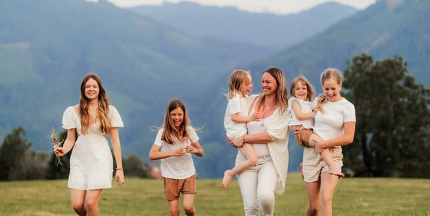 Familie läuft lachend auf einer Wiese