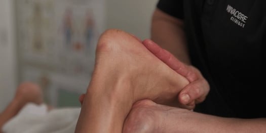a person with a foot on a bed doing sport therapy