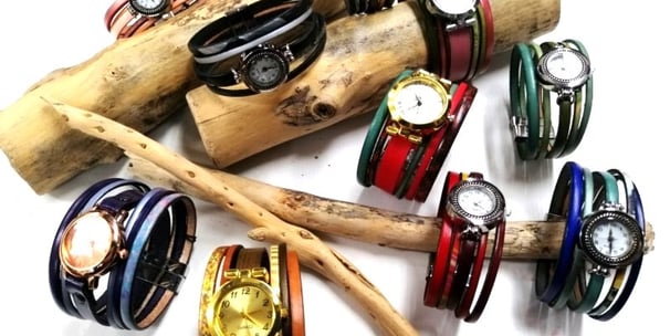 a bunch of bracelets and watches on a stick