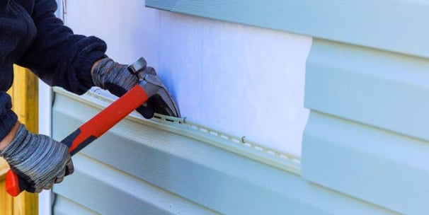 Man replacing siding on a home