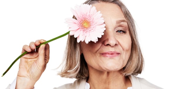 uma senhora segurando uma flor recebendo dicas para o tratamento da menpausa
