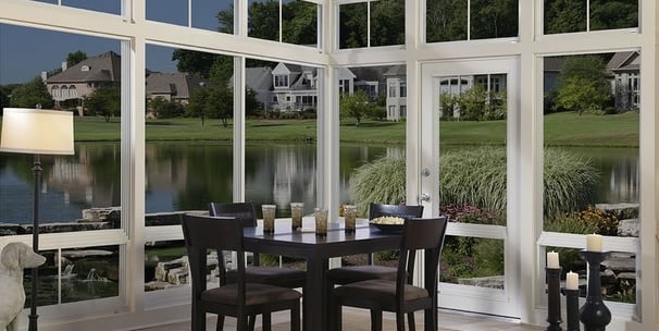 Three 3 seasons sunroom a dining room with a table and chairs