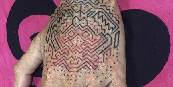 An handpoke tattoo featuring geomatric line symmetrical pattern, art tappis ornaments inspired.