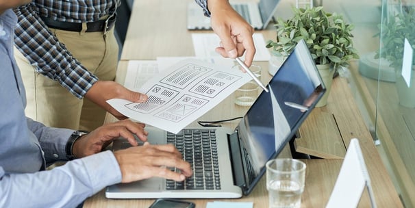 Deux hommes travaillant sur des ordinateurs portables dans une salle de réunion.