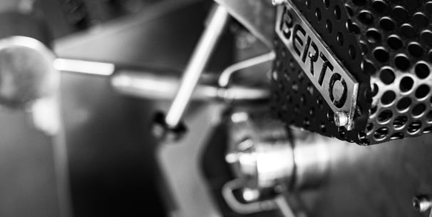 a close up of a coffee roasting machine with a metal frame