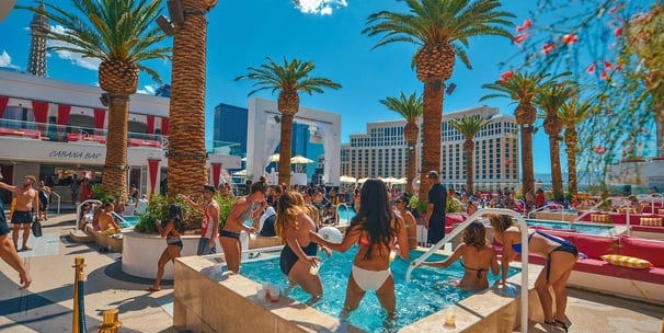 Luxury poolside cabanas and guests enjoying bottle service at a Vegas dayclub, representing VIP tips and upscale planning.