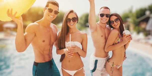 Group of stylish friends in swimwear at a Vegas pool party, showing ideal dayclub dress code