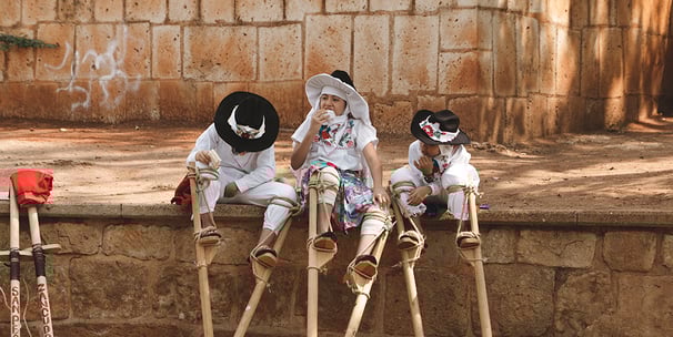 narrativa cultural: three children in white dresses and hats sitting on a ledge