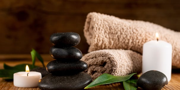 massage stones, candle and towels