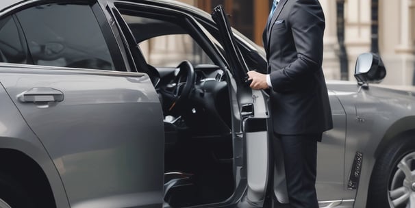 a man in a suit and tie standing next to a car