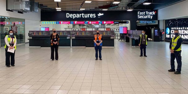 Staff standing apart in the departures security area