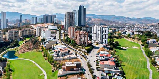 Vista panorámica de edificios de departamentos y casas en Bosque Real, rodeados por el campo de golf
