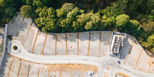 Vista aérea de una privada de lotes residenciales en Bosque Real, rodeada de naturaleza