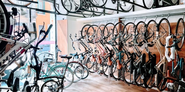 a room with many bikes and bicycles parked in front of a store