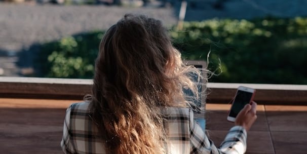 a woman sitting on a bench looking at her cell phone