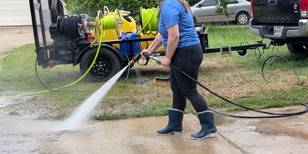 Women washing a drive way with a pressure washer