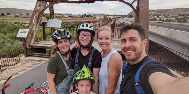 family in front of bridge on bike ride