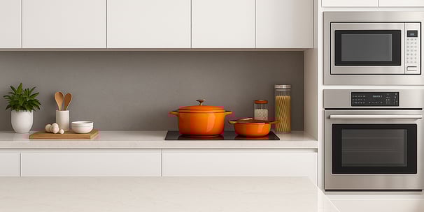 White kitchen with quartz countertops, flat-panel cabinets, and premium stainless appliances.