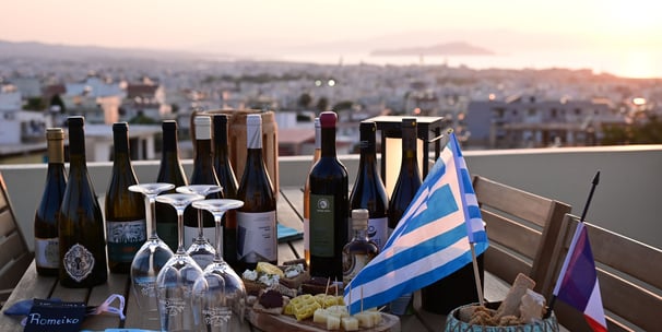 a table with greek wine bottles and glasses on it at La Canée