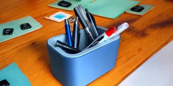 a desk with a pen and pencils on it