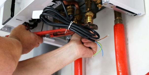 a man is fixing a water heater in a room