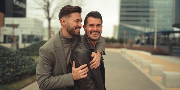 Pareja LGBTQ+ riendo juntos en un momento divertido en la ciudad, foto de boda íntima y con estilo en Madrid