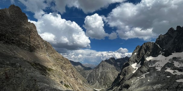 a person standing on a mountain top with a view of a valley