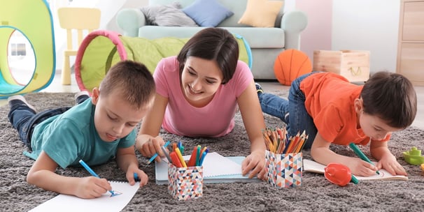 girl with two children colouring