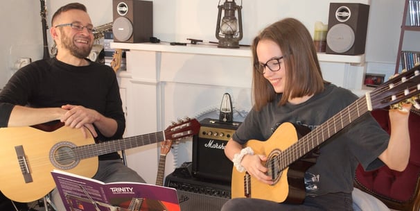 A guitar lesson with a young adult student