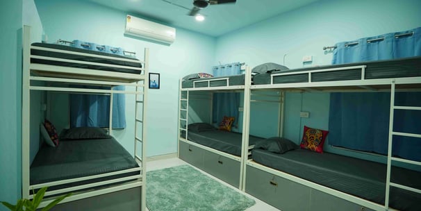 a blue room with bunk beds and a fan