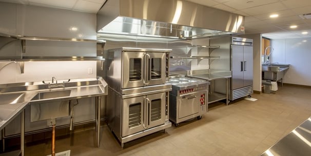 commercial kitchen setting containing commercial ovens and various commercial appliances