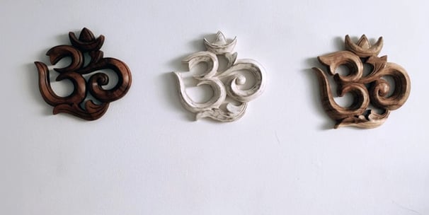 three wooden carvings of a Om religous symbol
