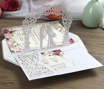 a wedding card with a couple of people standing in front of a bouquet