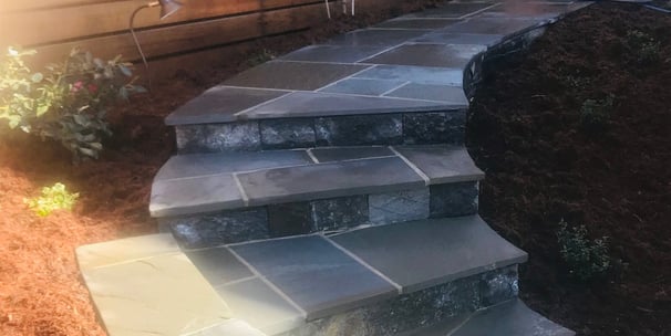 a stone stepstone with a stone steps leading up to a house