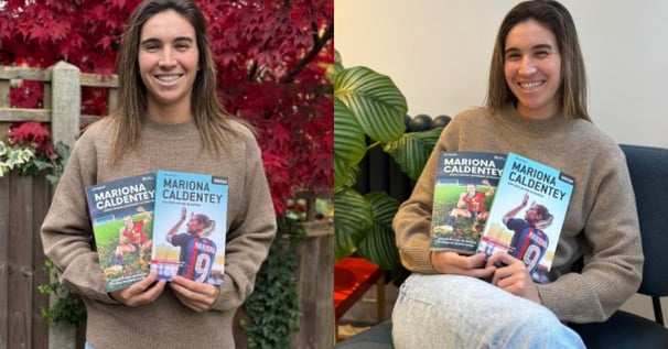 two women holding up their books and smiling