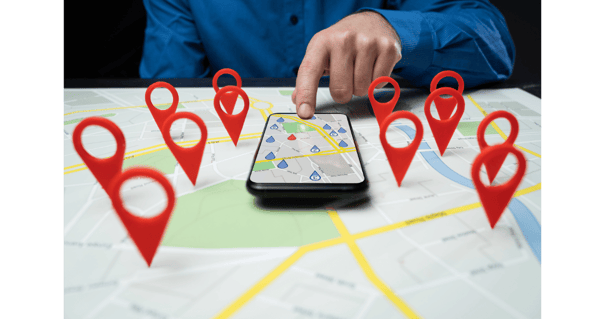 Hand using map on smartphone with location pins | Local SEO and business targeting