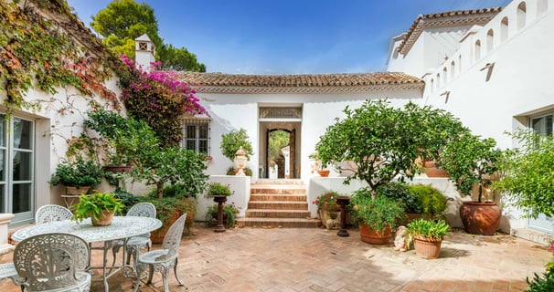 Rustic Spanish villa for rent featuring a charming ivy-covered patio