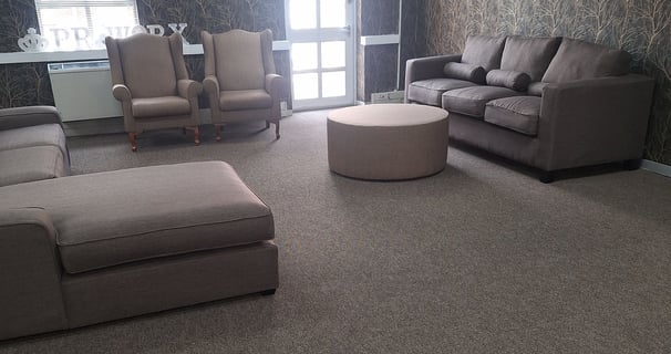 Finished lounge area with custom carpeting, blinds, and modern furnishings.