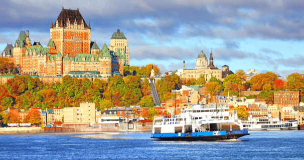 a boat in the water overlooking the Quebec City, Canada skyline
