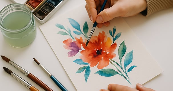 Une personne est en train de peindre une fleur à l’aquarelle.