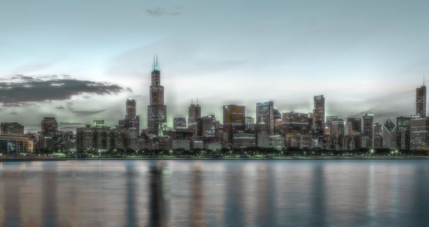 City skyline at dusk, reflected in water — symbolizing clarity, scale, and transition
