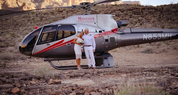 a man and woman standing in front of a helicopter