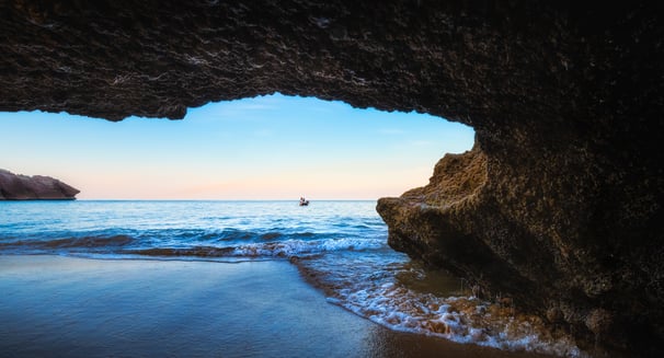 a person standing in front of a cave in a cave