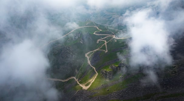 a mountain view of a winding road in the mountains. arbab naimat kasi Kalam