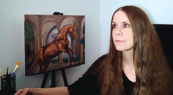 Carla Millar at desk with her oil painting in the background.