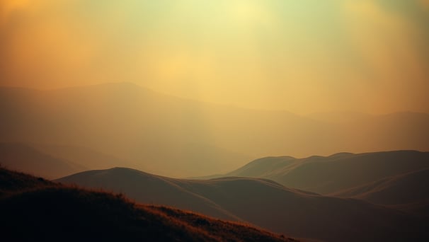 UniverseX - a person standing on a hill with a sky background